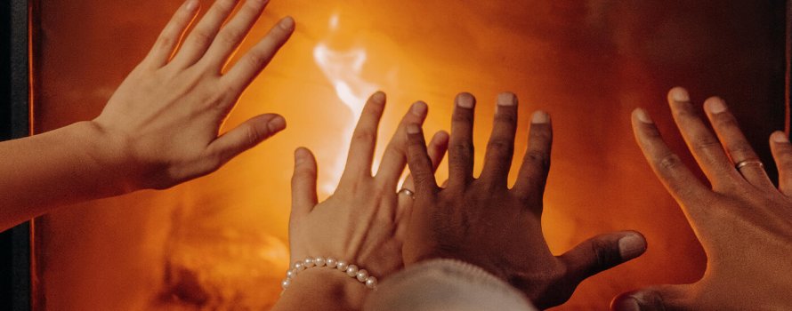 Hands keeping warm by the fireplace