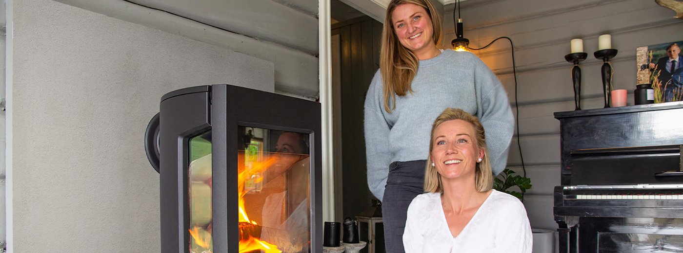 Two women standing in front of their wood stove Jøtul F 167