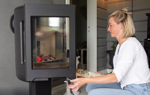 Girl putting wood in the Jøtul F 167 wood stove